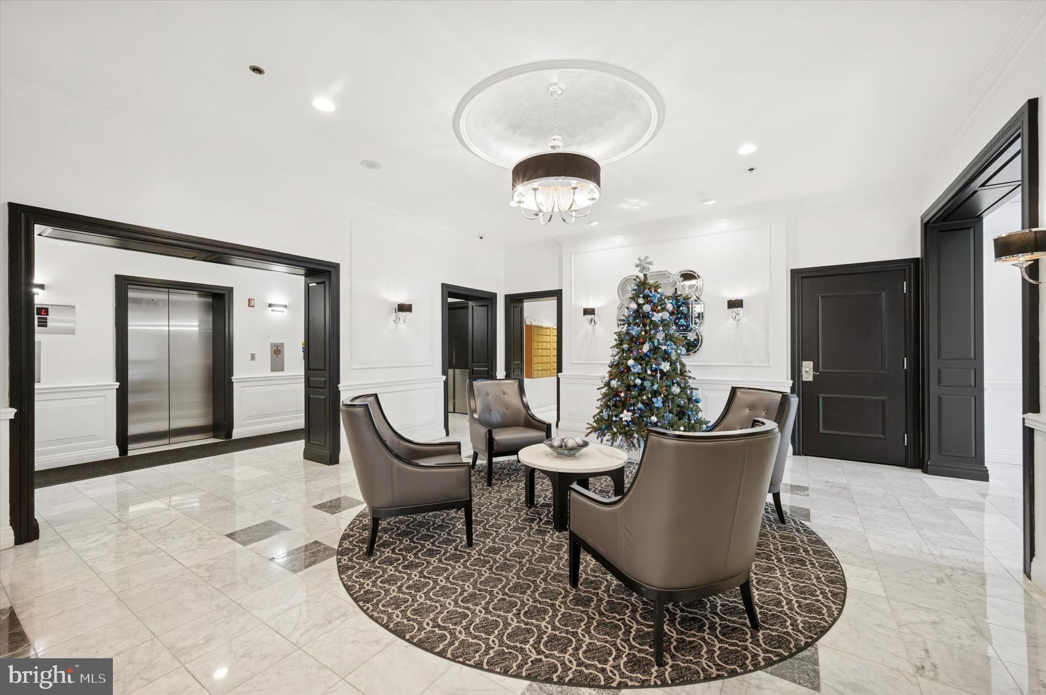 2001 Hamilton Street, Unit 1221 Philadelphia, PA 19130 - Photo 2 of 27 a living room with furniture a chandelier and a glass door