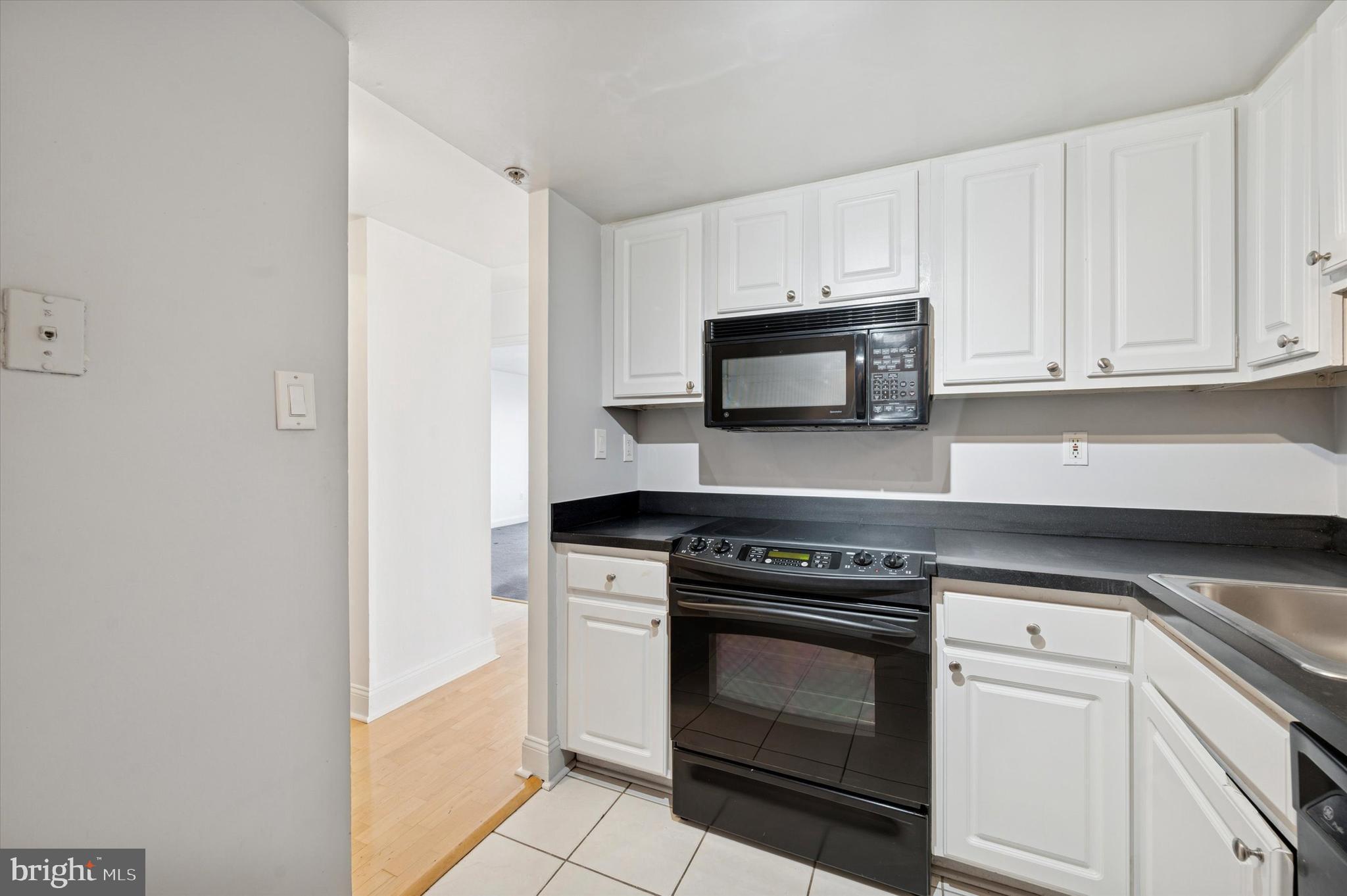 2001 Hamilton Street, Unit 1221 Philadelphia, PA 19130 - Photo 8 of 27 a kitchen with granite countertop white cabinets and stainless steel appliances