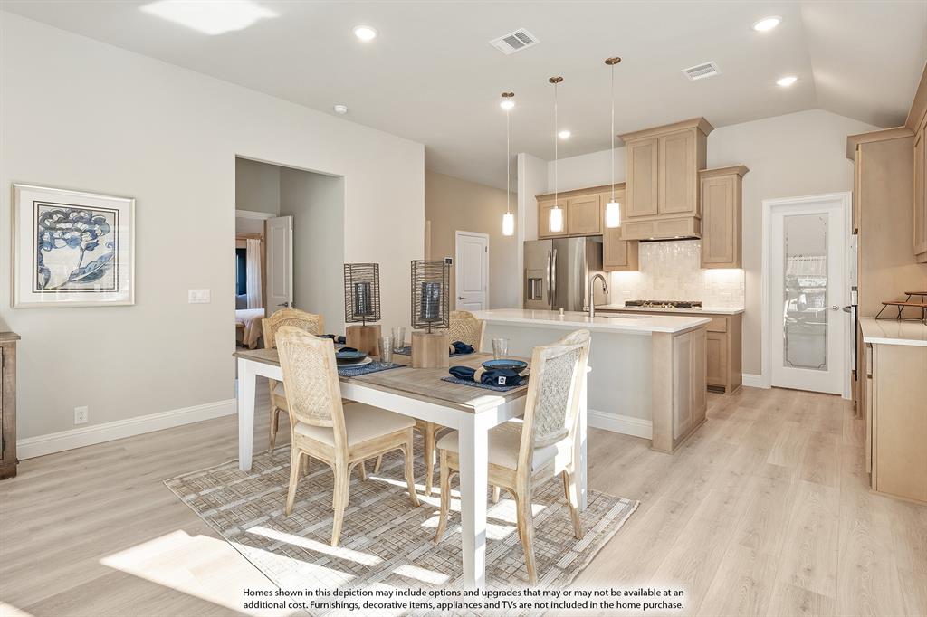 14550 Lovelace Street Pilot Point, TX 76258 - Photo 11 of 23 a kitchen with stainless steel appliances kitchen island granite countertop a dining table chairs and white cabinets