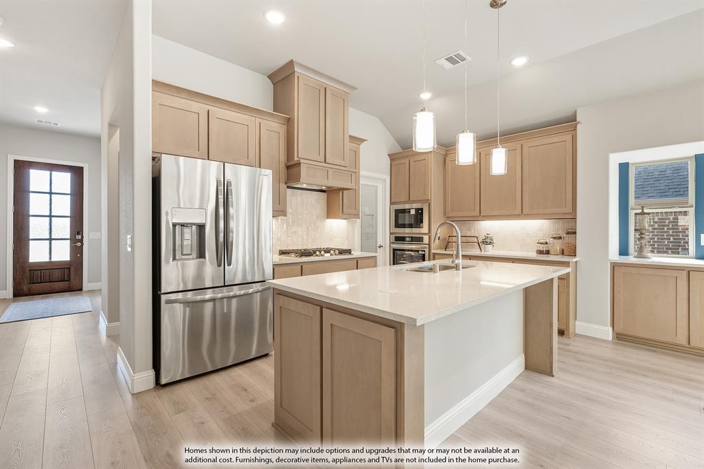 14550 Lovelace Street Pilot Point, TX 76258 - Photo 5 of 23 a kitchen with stainless steel appliances kitchen island granite countertop a refrigerator and a sink