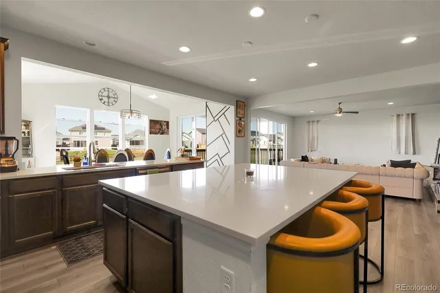 a kitchen with stainless steel appliances granite countertop a sink a counter and chairs