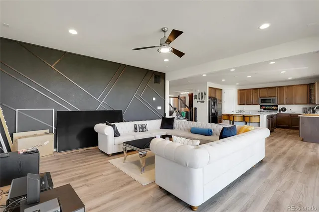a living room with furniture kitchen view and a chandelier