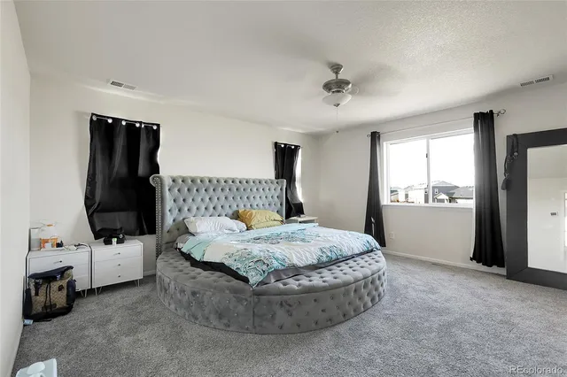 a bed sitting in a room next to a window and dresser