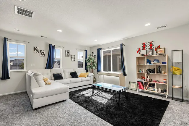 a living room with furniture and a book shelf