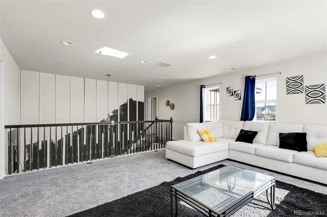 a living room with furniture and a book shelf