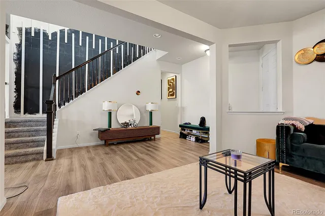 a living room with furniture and a wooden floor