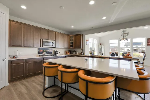 a large kitchen with a table chairs sink and cabinets