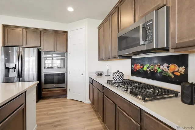 a kitchen with stainless steel appliances a stove a microwave and a refrigerator