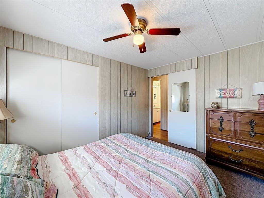 1100 South Belcher Road, Unit 561 Largo, FL 33771 - Photo 14 of 23 a bedroom with a bed and a chandelier