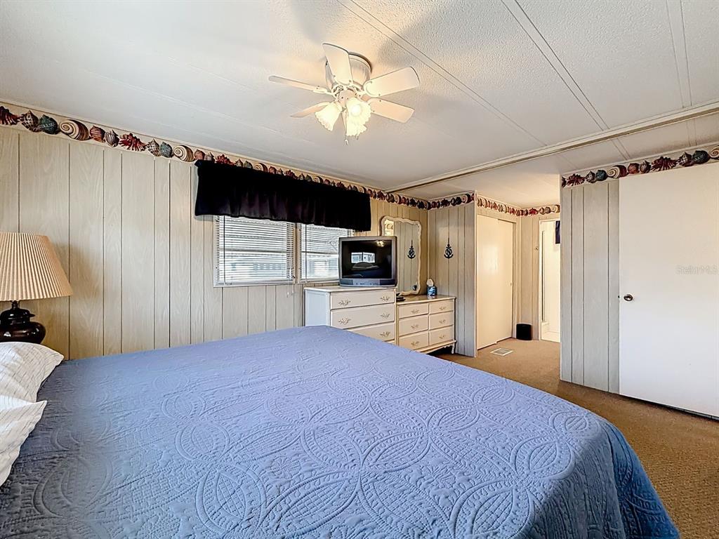 1100 South Belcher Road, Unit 561 Largo, FL 33771 - Photo 18 of 23 a spacious bedroom with a bed and a flat screen tv