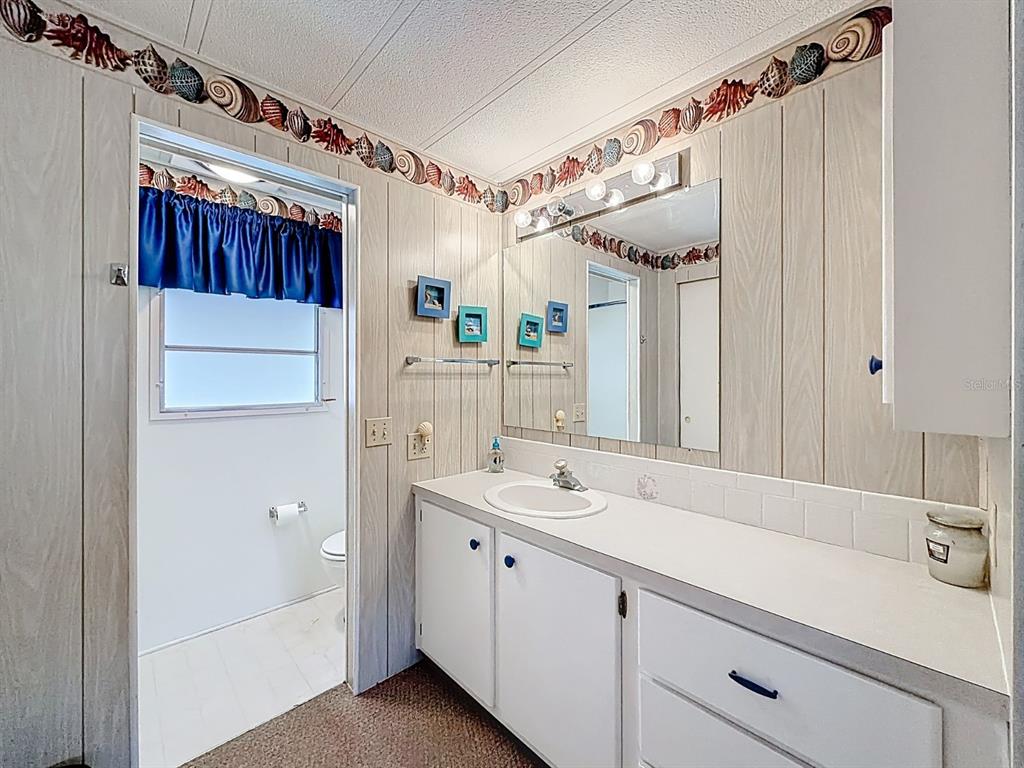 1100 South Belcher Road, Unit 561 Largo, FL 33771 - Photo 19 of 23 a bathroom with a sink vanity mirror and shower