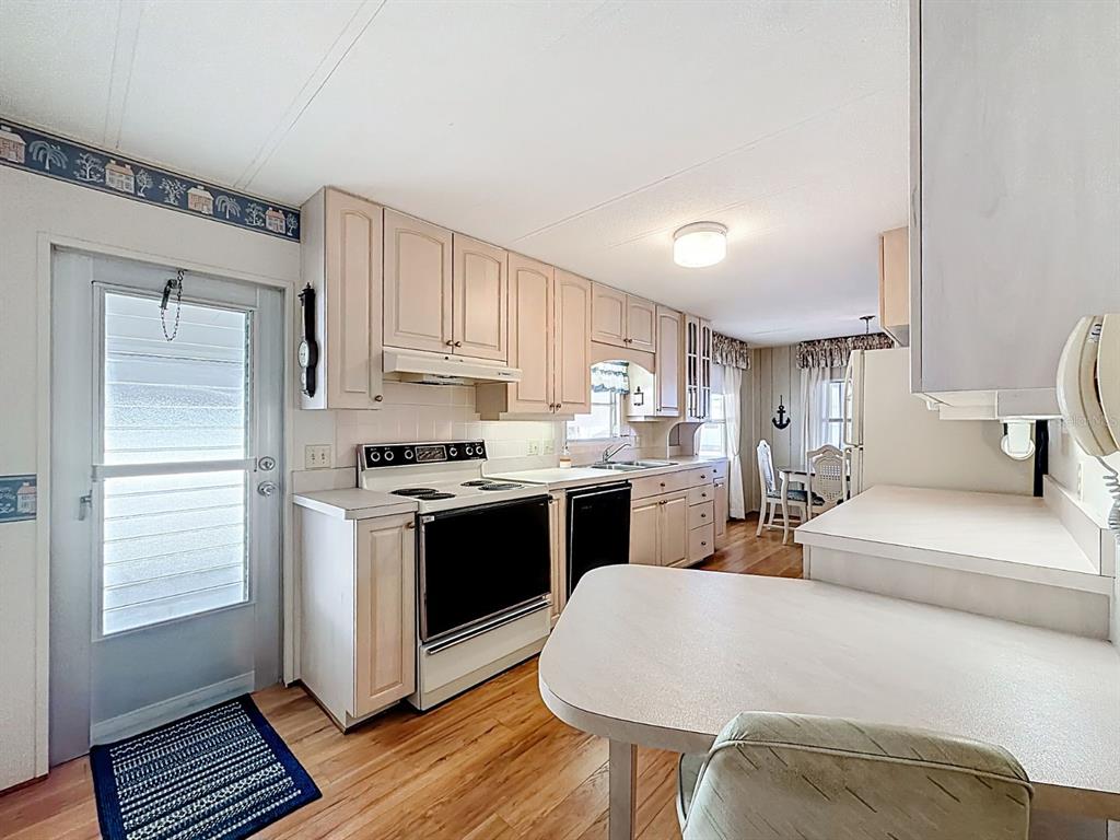 1100 South Belcher Road, Unit 561 Largo, FL 33771 - Photo 7 of 23 a kitchen with stainless steel appliances granite countertop a stove a sink and a refrigerator