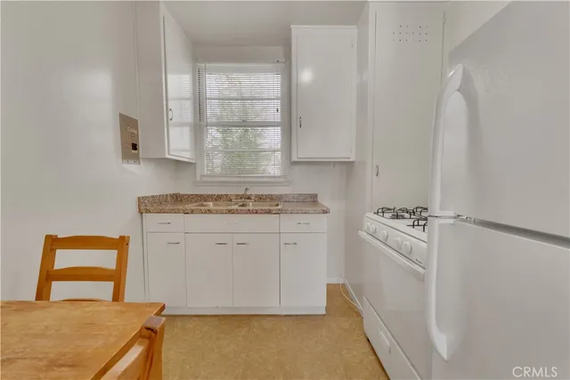 a kitchen with white cabinets and white appliances