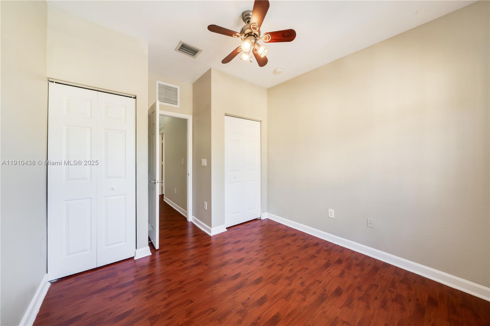 9239 Southwest 227th Street, Unit 4 Cutler Bay, FL 33190 - Photo 21 of 29 an empty room with wooden floor and a ceiling fan