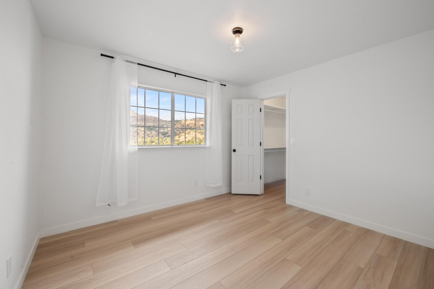 38570 Rustic Lane Squaw Valley, CA 93675 - Photo 16 of 43 a view of an empty room with wooden floor and a window