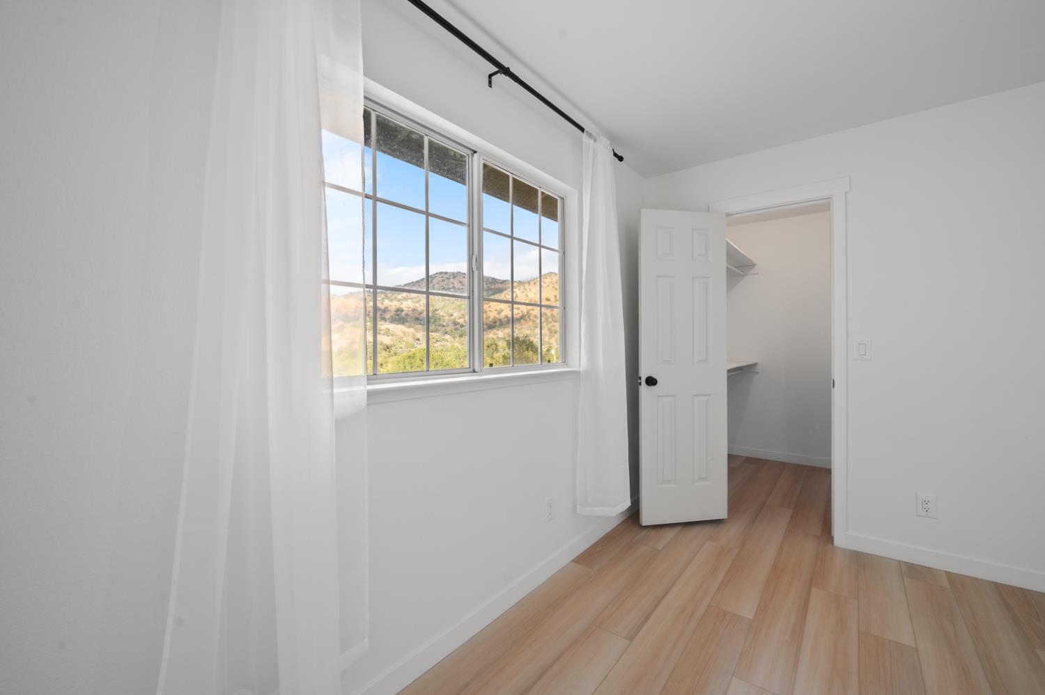 38570 Rustic Lane Squaw Valley, CA 93675 - Photo 17 of 43 a view of an empty room with wooden floor and a window