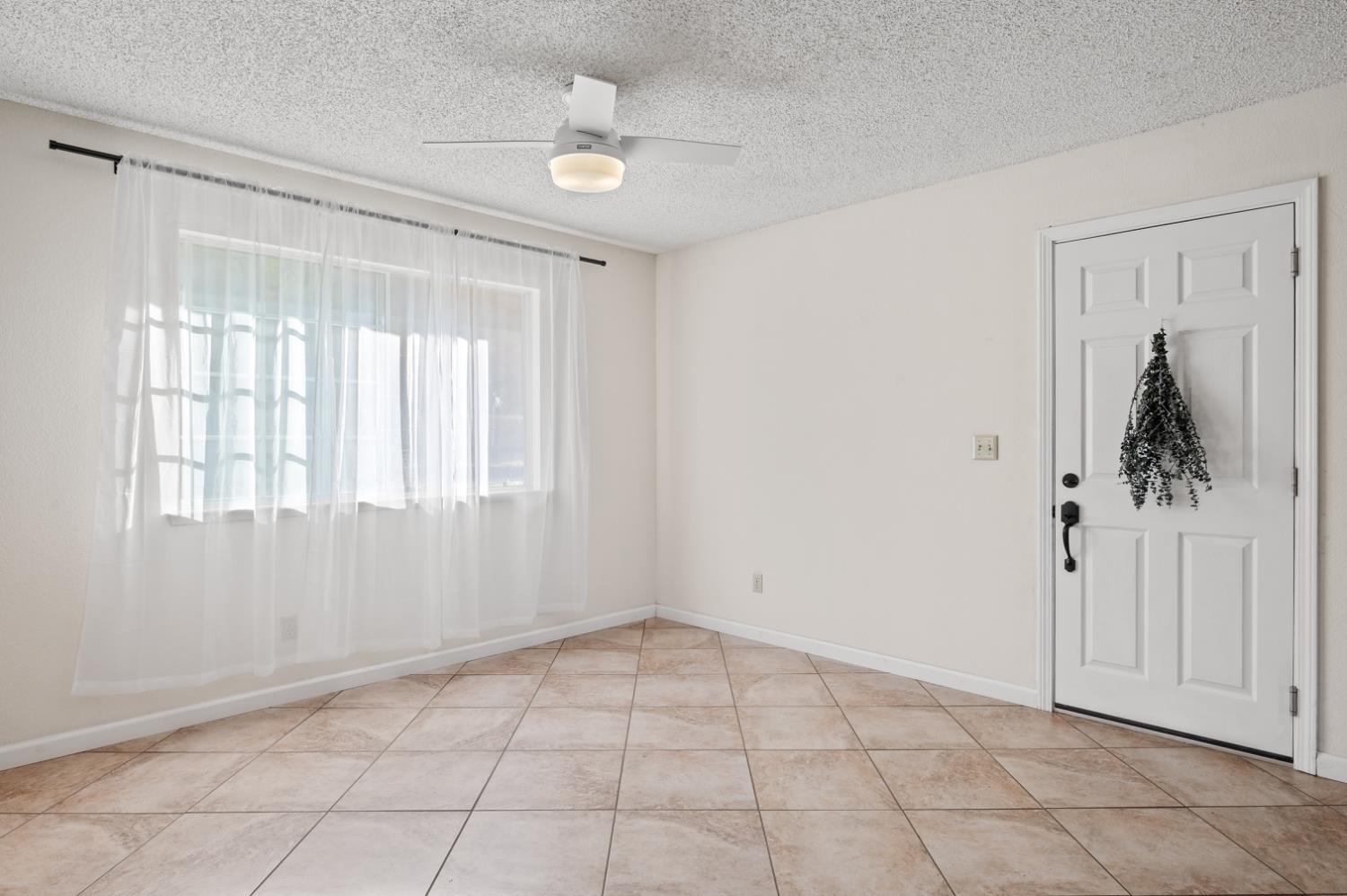 38570 Rustic Lane Squaw Valley, CA 93675 - Photo 8 of 43 a view of an empty room with window and chandelier fan