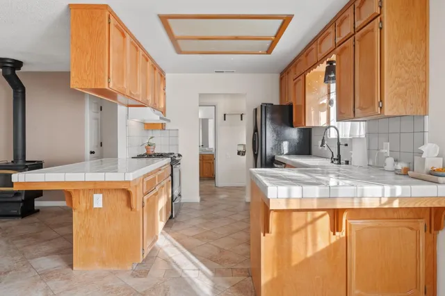 a kitchen with stainless steel appliances granite countertop a sink a stove and a refrigerator