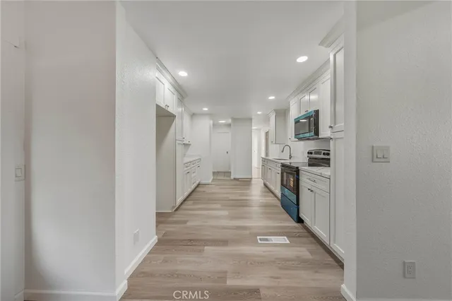 a kitchen with white cabinets and stainless steel appliances