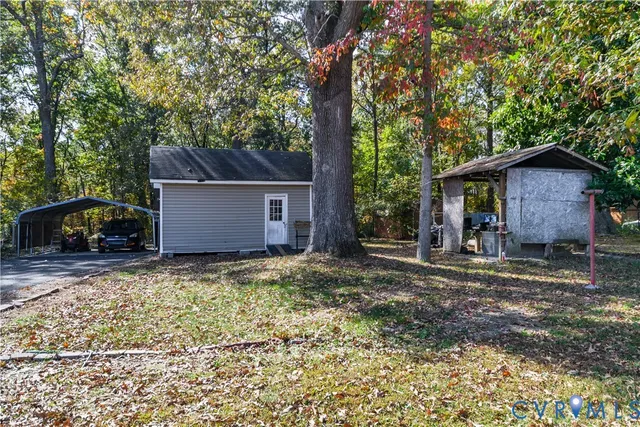 a view of a house with a yard and large tree