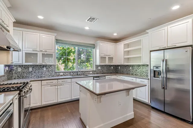 a kitchen with stainless steel appliances granite countertop a sink stove and refrigerator