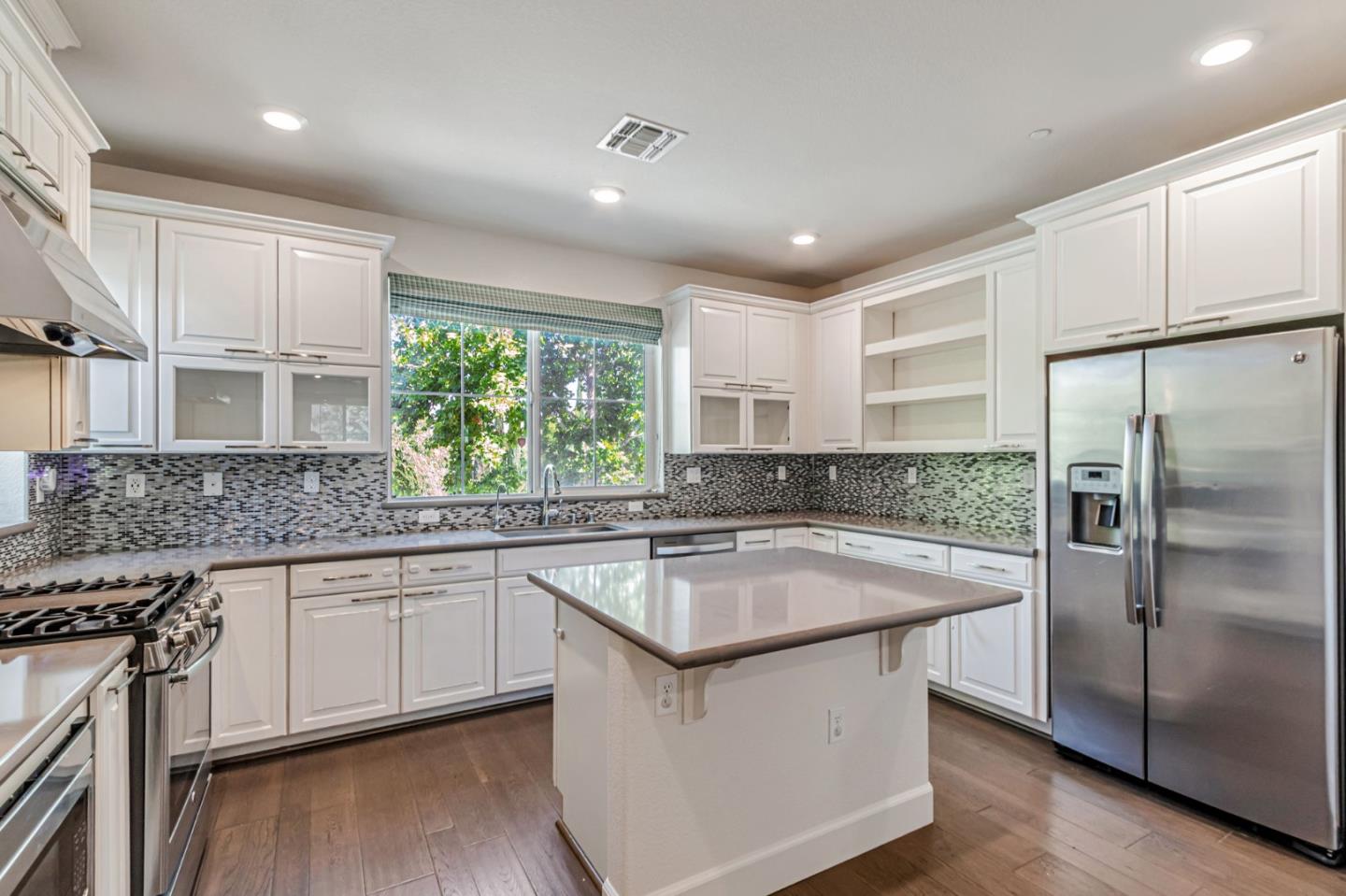 a kitchen with stainless steel appliances granite countertop a sink stove and refrigerator
