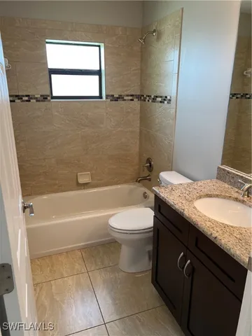 a bathroom with a granite countertop toilet a sink and bathtub