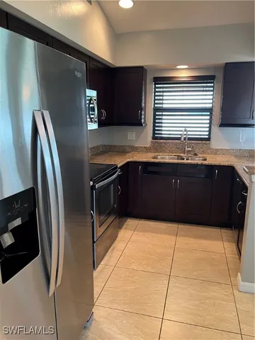 a large kitchen with stainless steel appliances granite countertop a refrigerator and a sink