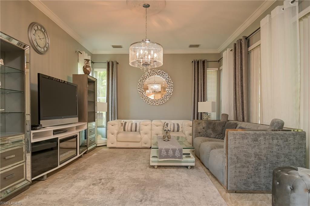 3144 Sundance Circle Naples, FL 34109 - Photo 15 of 26 Living area with crown molding and a chandelier