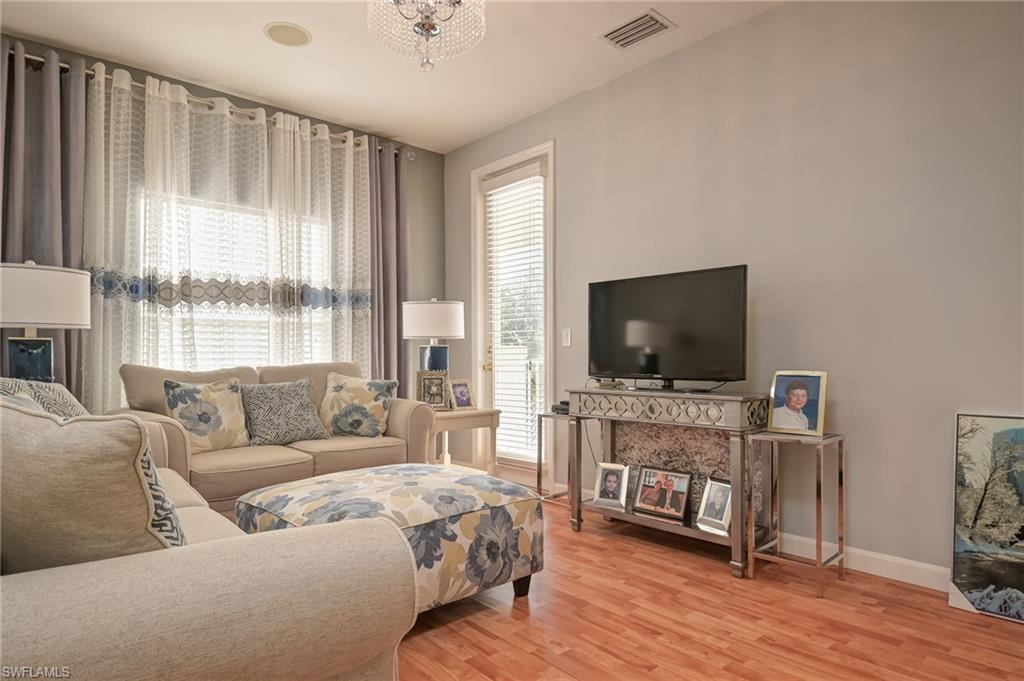 3144 Sundance Circle Naples, FL 34109 - Photo 19 of 26 Living area featuring light wood-style floors, plenty of natural light, and a chandelier