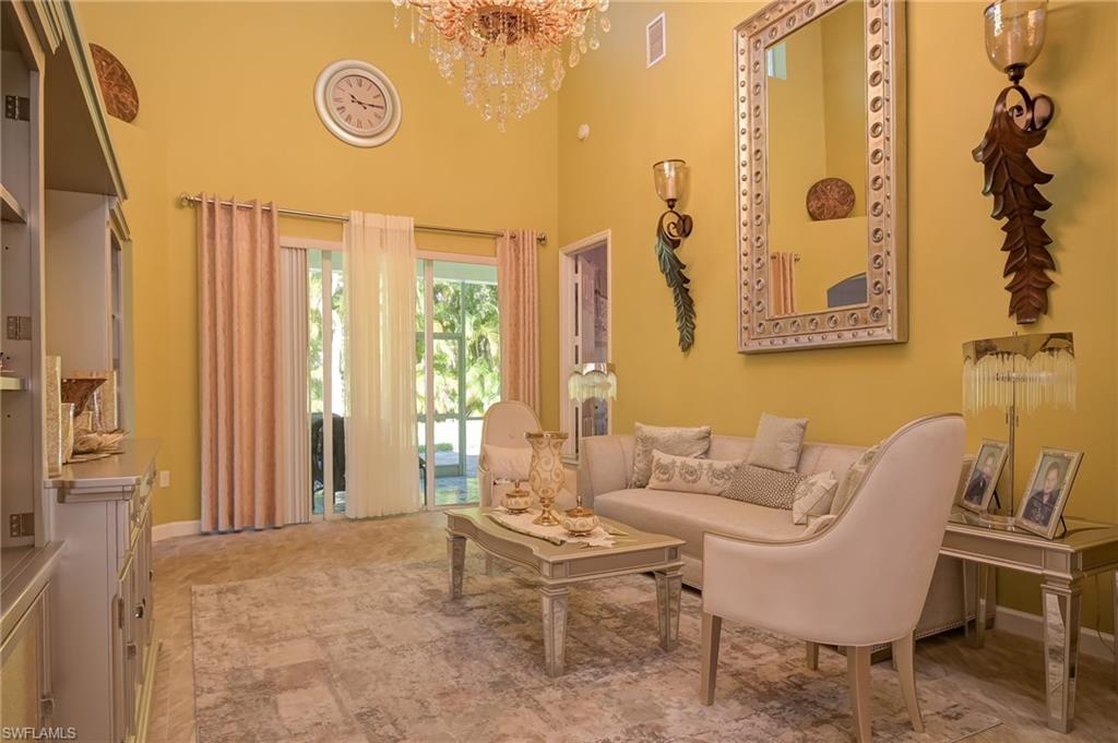 3144 Sundance Circle Naples, FL 34109 - Photo 9 of 26 Living area featuring a high ceiling and a chandelier