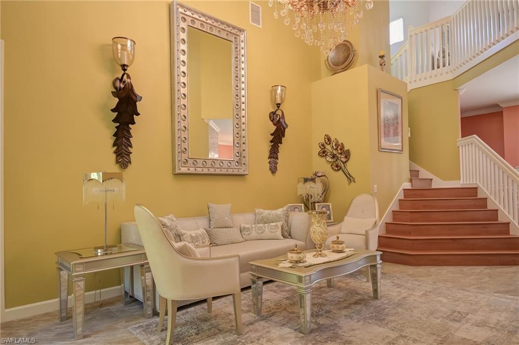 3144 Sundance Circle Naples, FL 34109 - Photo 10 of 26 Sitting room with a towering ceiling, stairs, and a chandelier