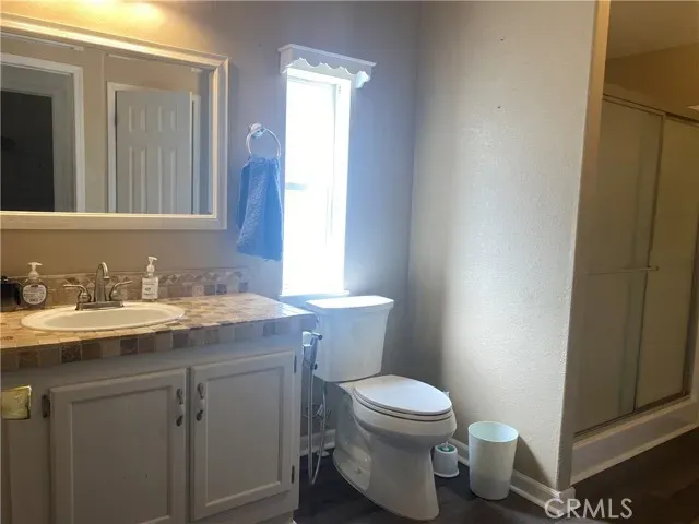 a bathroom with a granite countertop toilet sink and mirror
