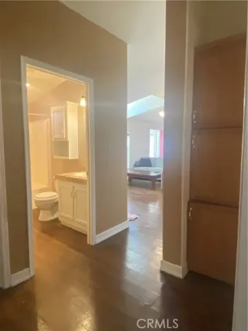 a view of a bathroom with a glass door and a wooden floor