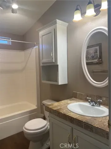 a bathroom with a granite countertop sink toilet and a mirror