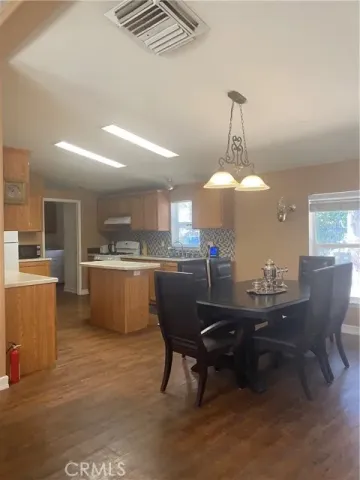 a dining room with a table chairs and a kitchen