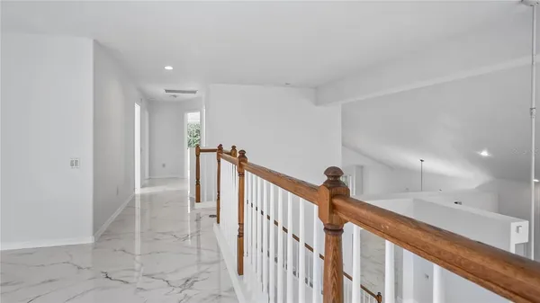 an empty room with windows and ceiling fan