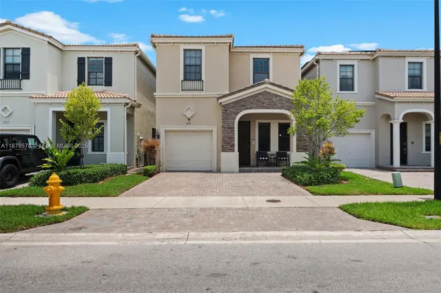 a front view of a house with a yard and a garage