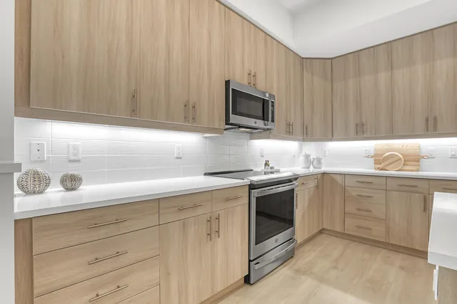 a kitchen with granite countertop white cabinets and stainless steel appliances