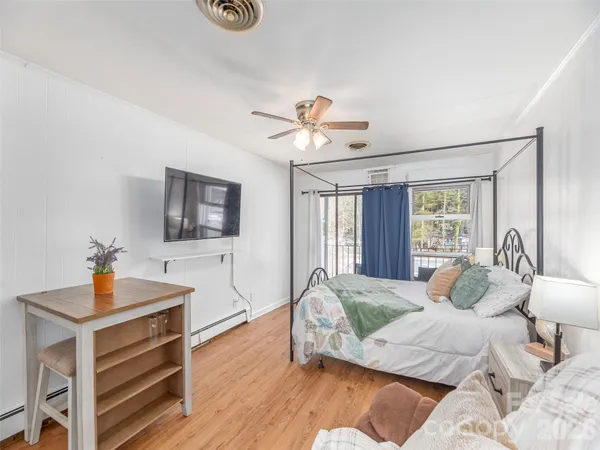 a spacious bedroom with a bed and a flat screen tv