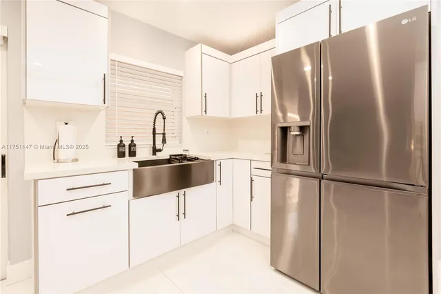 a kitchen with granite countertop a refrigerator and a sink