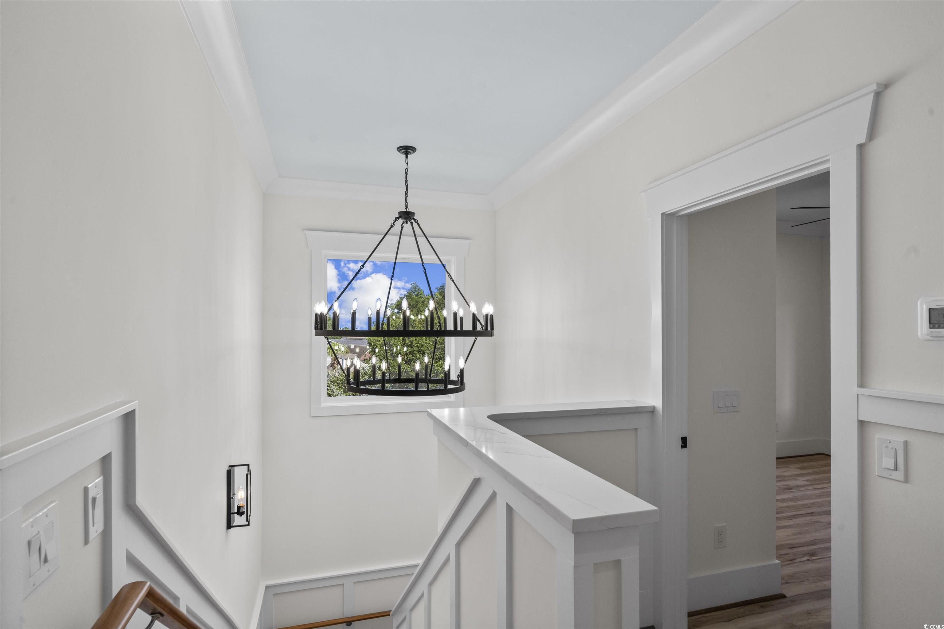 1017 Hyatt Pond Road North Myrtle Beach, SC 29582 - Photo 11 of 39 Corridor featuring a chandelier, wood finished floors, and ornamental molding