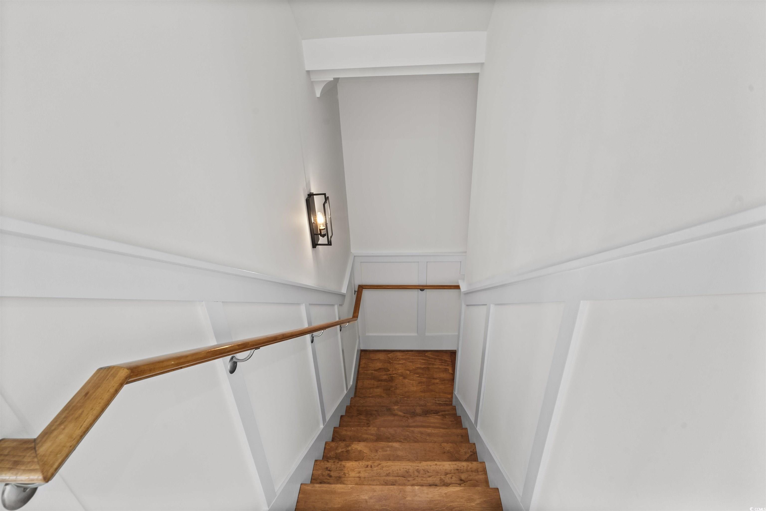 1017 Hyatt Pond Road North Myrtle Beach, SC 29582 - Photo 27 of 39 Stairs featuring wainscoting, wood finished floors, and a decorative wall