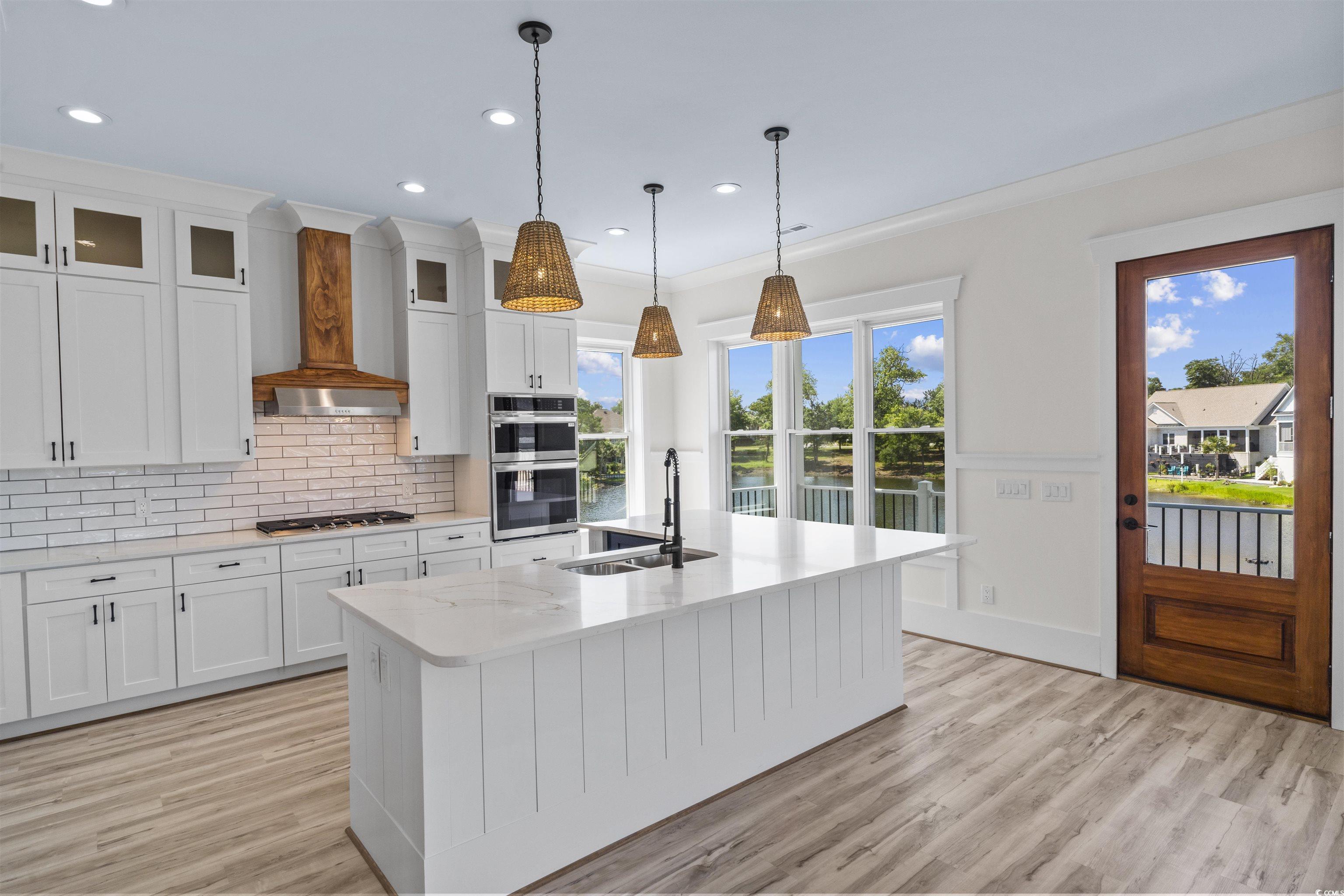 1017 Hyatt Pond Road North Myrtle Beach, SC 29582 - Photo 3 of 39 Kitchen with backsplash, light wood finished floors, white cabinets, recessed lighting, and ornamental molding