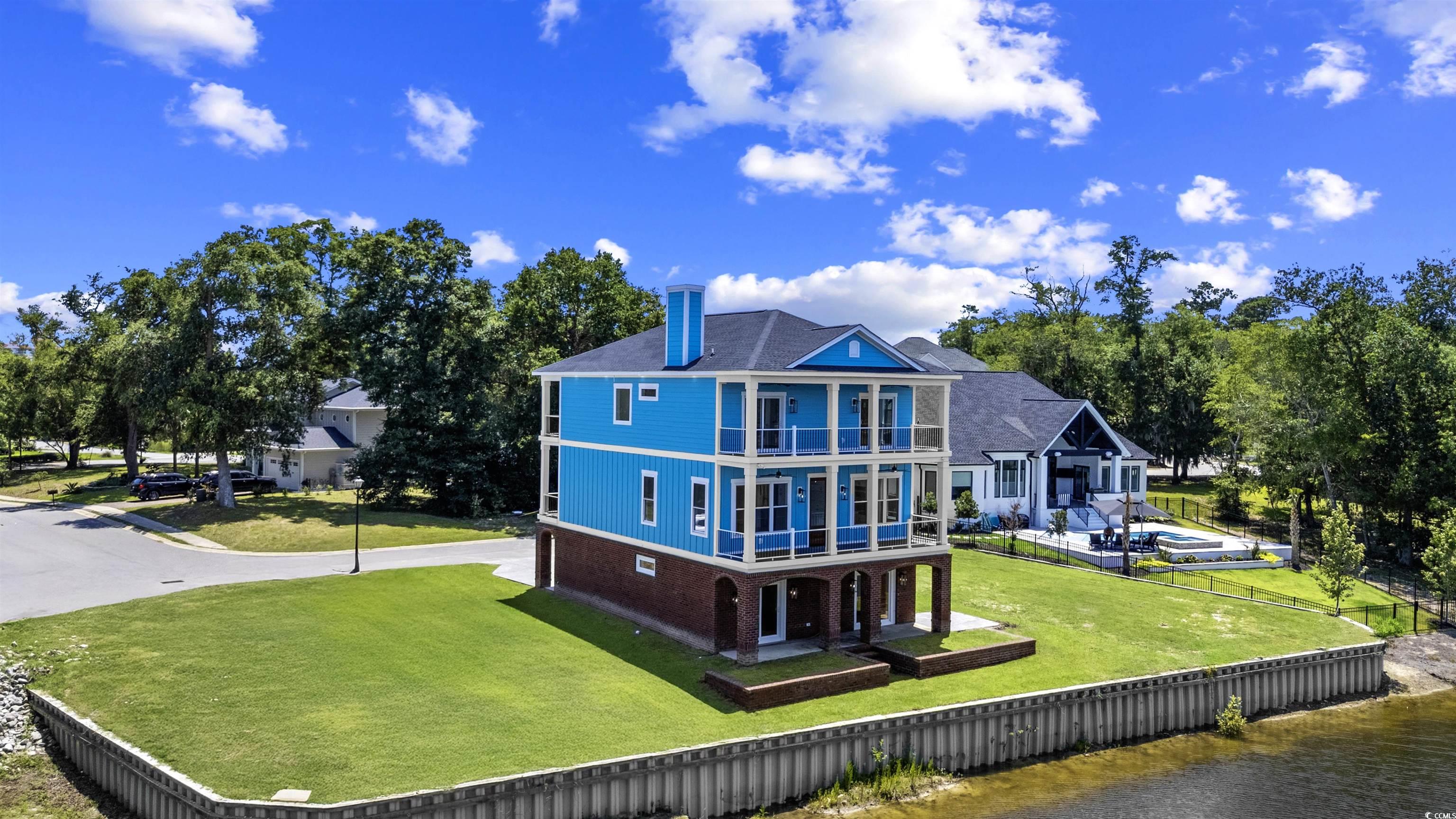 1017 Hyatt Pond Road North Myrtle Beach, SC 29582 - Photo 35 of 39 Rear view of house featuring a balcony, a water view, and brick siding