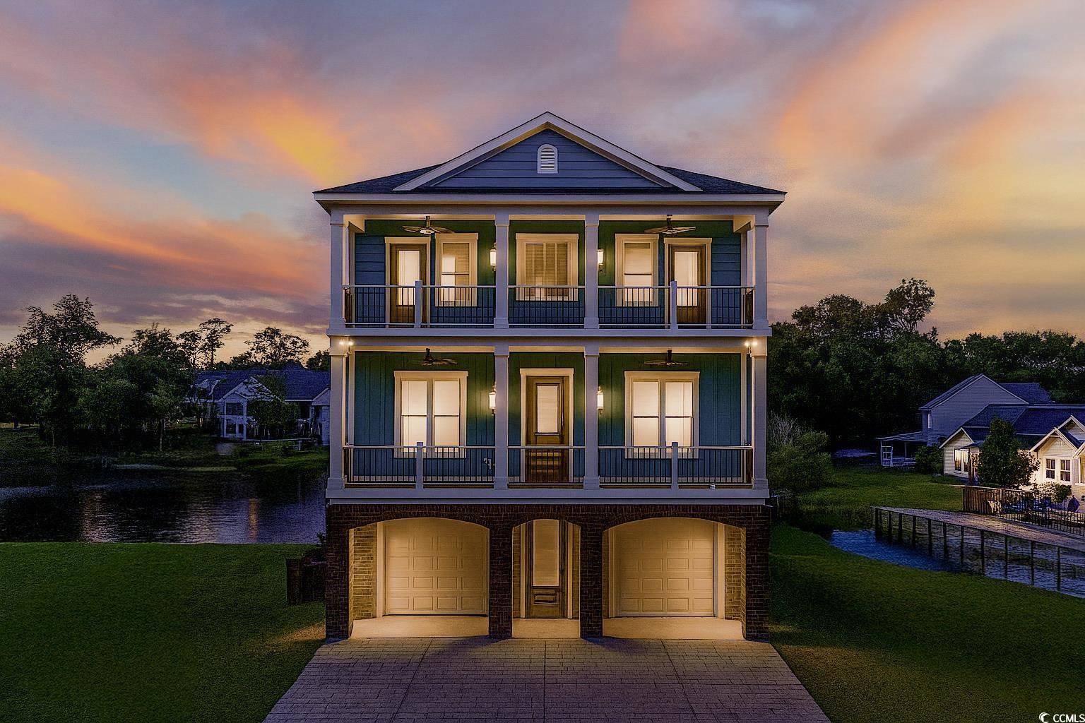 1017 Hyatt Pond Road North Myrtle Beach, SC 29582 - Photo 39 of 39 Sunset of house featuring a balcony, a water view, a lawn, and a garage
