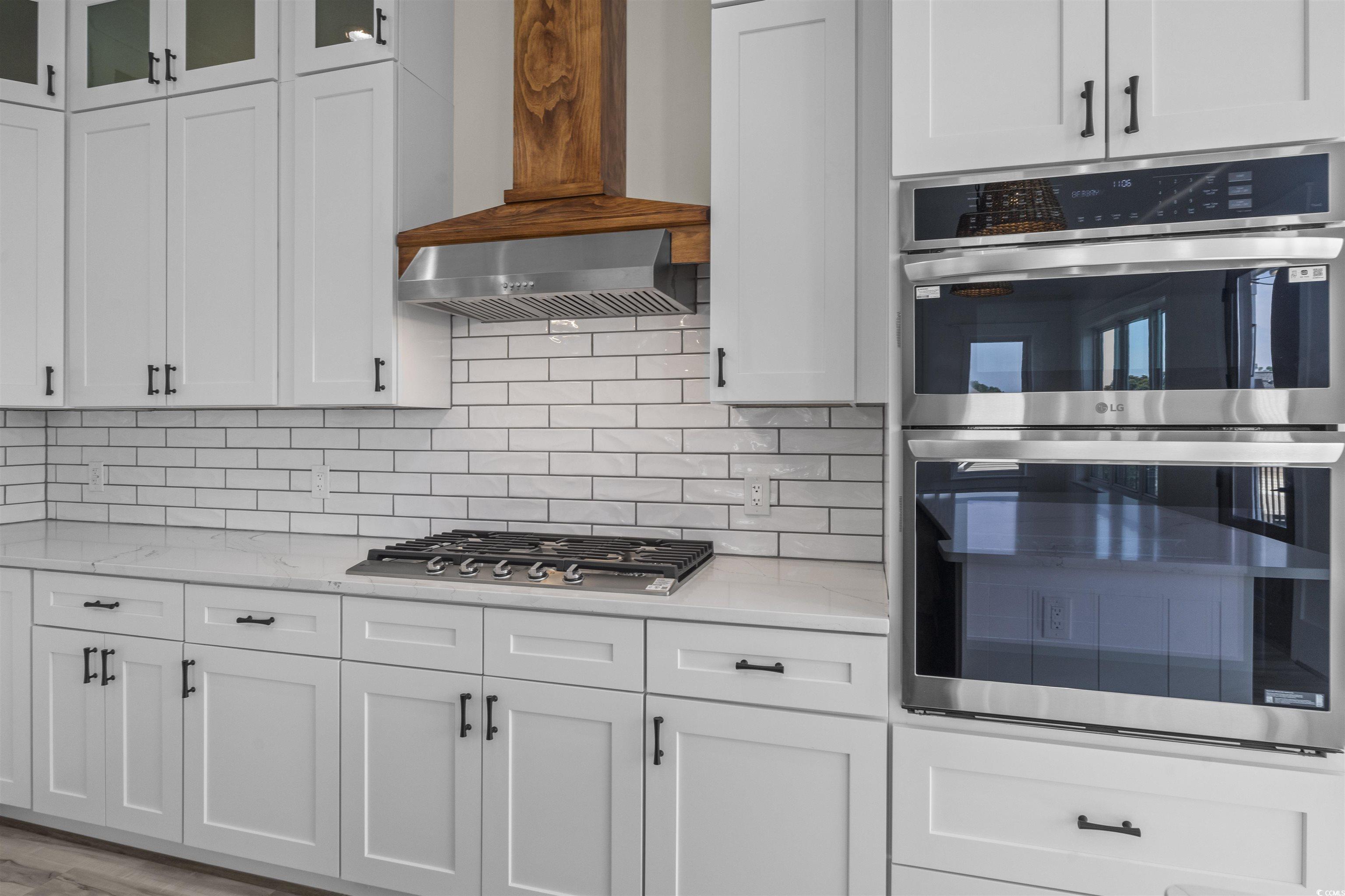 1017 Hyatt Pond Road North Myrtle Beach, SC 29582 - Photo 6 of 39 Kitchen with appliances with stainless steel finishes, white cabinets, and backsplash