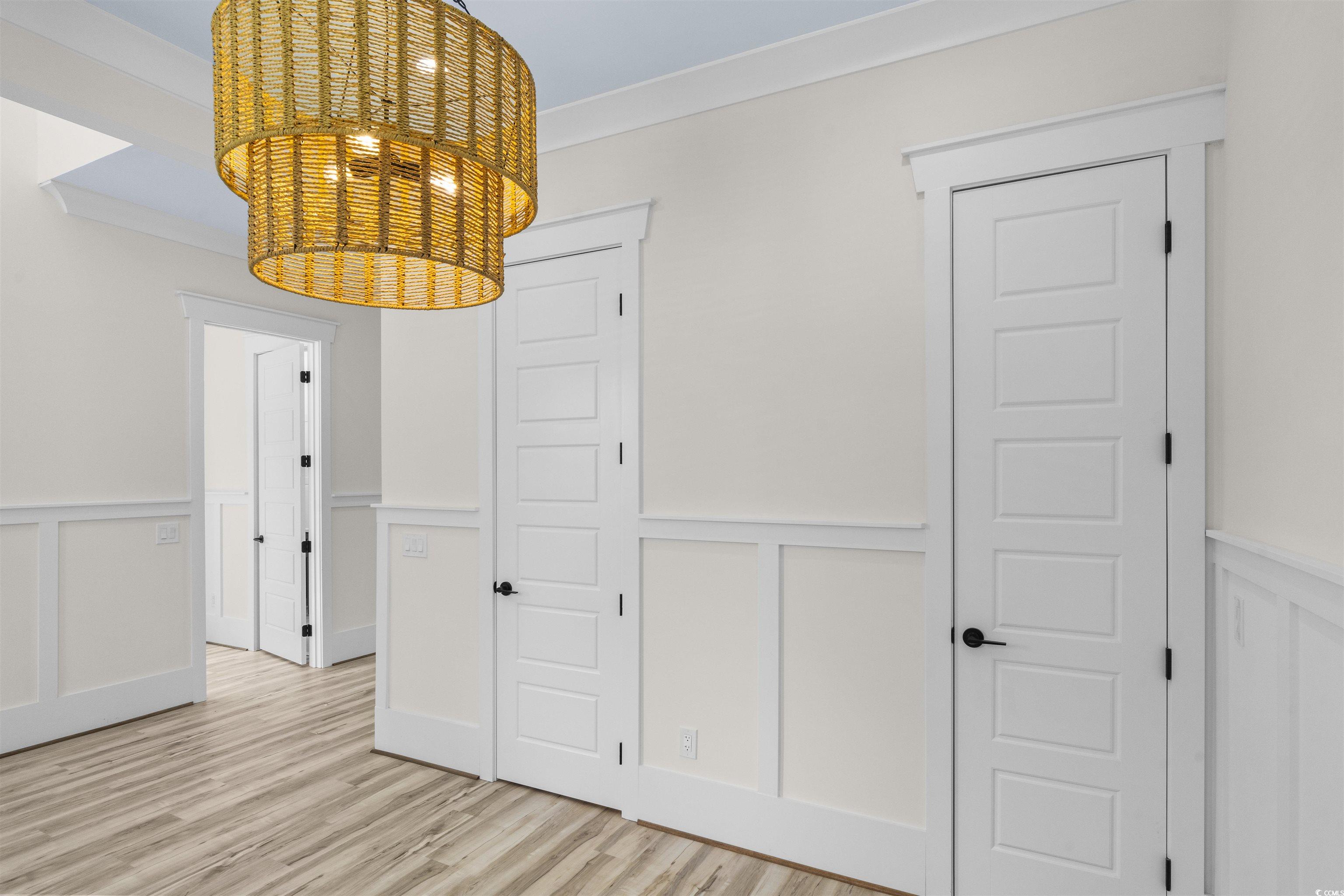 1017 Hyatt Pond Road North Myrtle Beach, SC 29582 - Photo 8 of 39 Unfurnished dining area featuring a decorative wall, a wainscoted wall, ornamental molding, and light wood-style floors