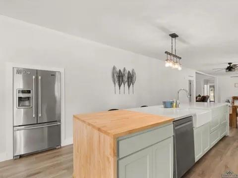 429 Private Road Big Sandy, TX 75755 - Photo 10 of 24 Kitchen with a kitchen island with sink, appliances with stainless steel finishes, decorative light fixtures, and light wood-type flooring