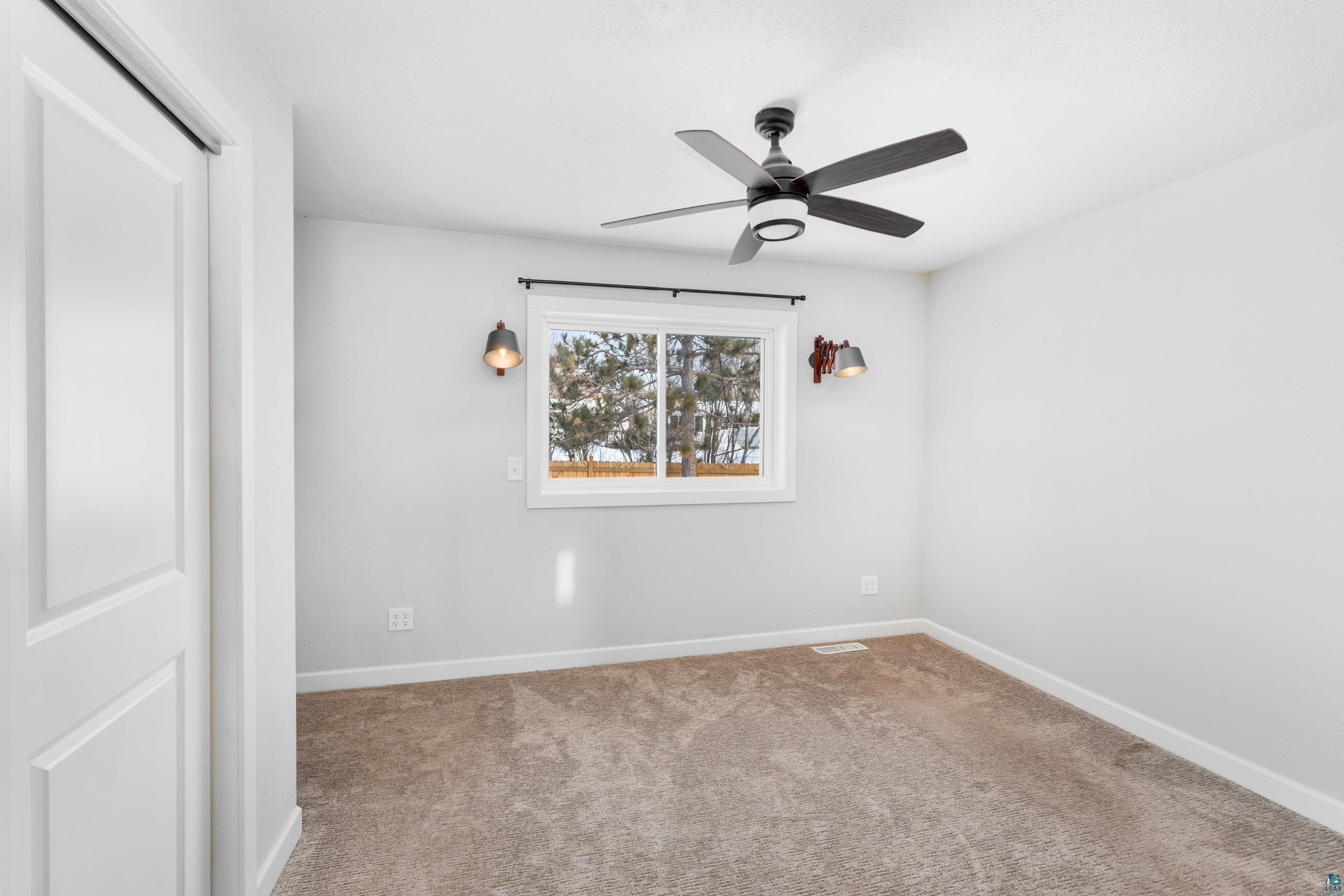 524 14th Avenue Two Harbors, MN 55616 - Photo 11 of 36 Unfurnished room featuring carpet and a ceiling fan